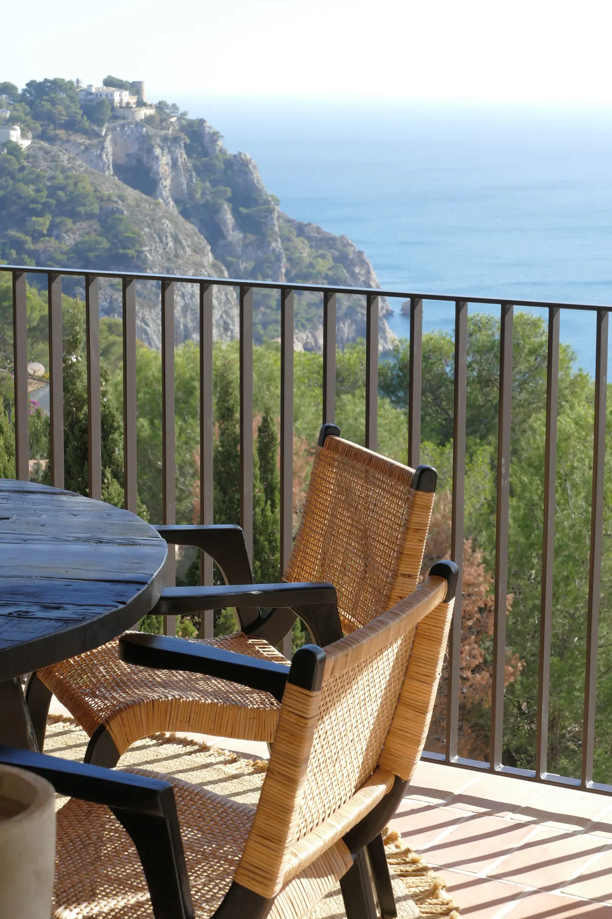 Ca L’Àmfora — woven chairs on a terrace overlooking the coastline