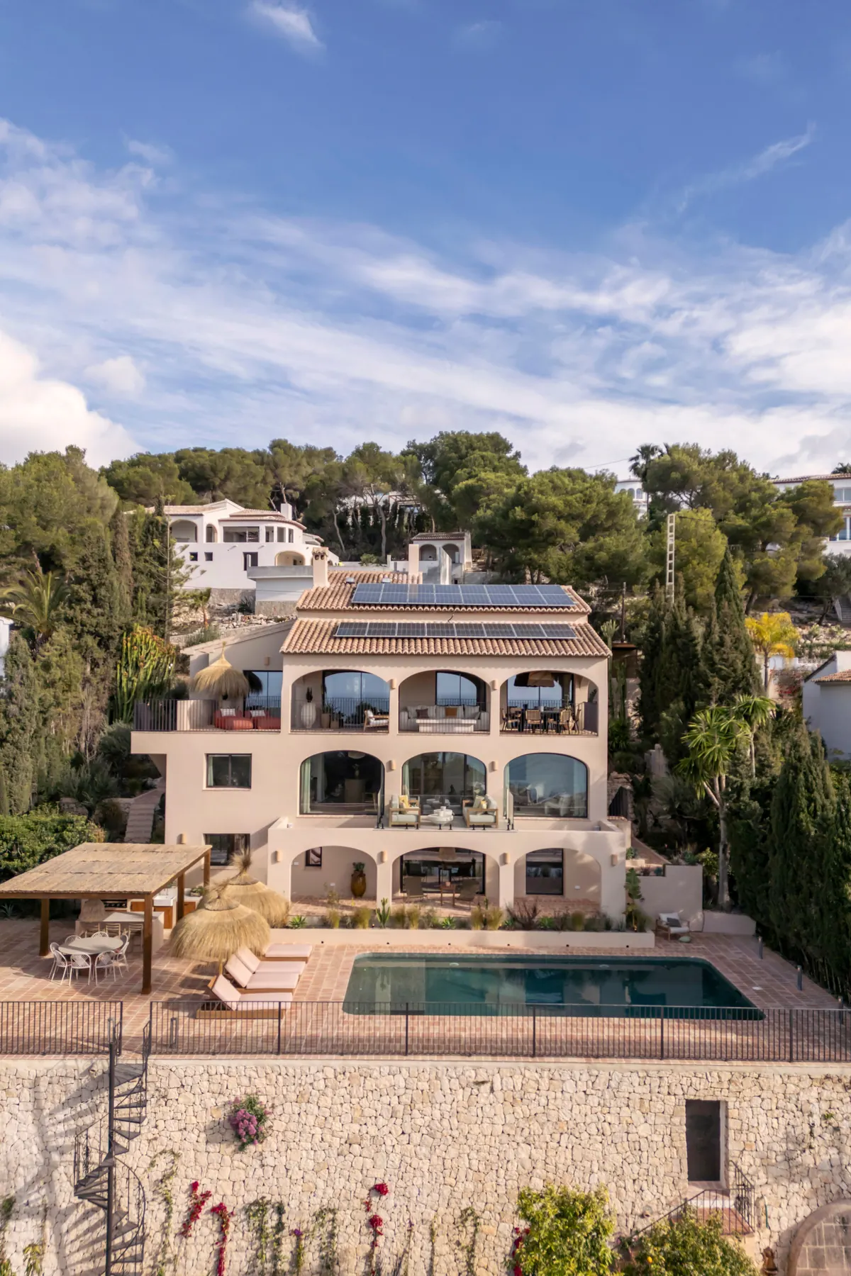 Ca L’Àmfora — a three-storey Mediterranean villa with arched terraces, solar panels and a pool, seen from above