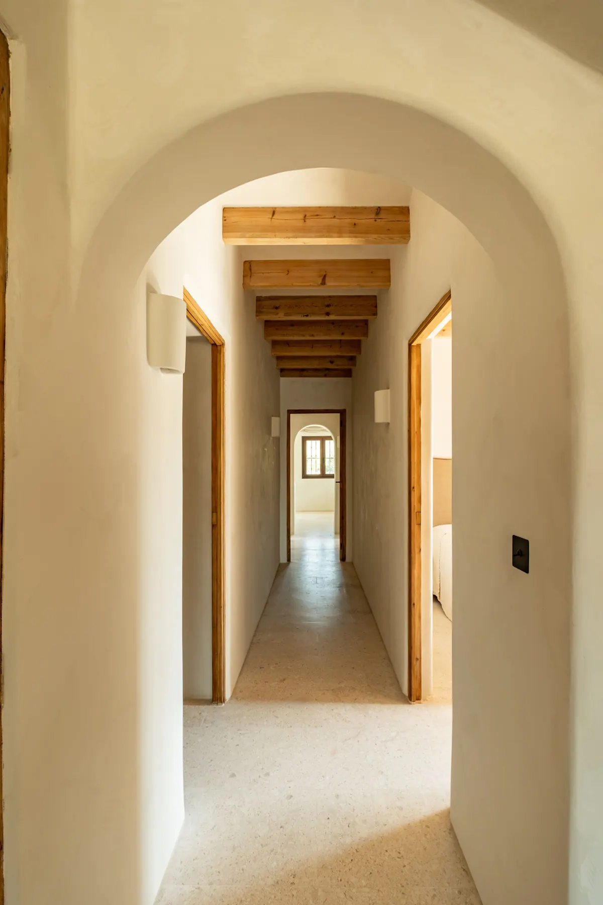 A long whitewashed corridor seen through a rounded arch